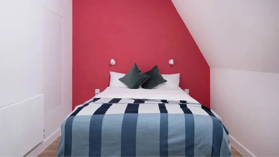Bed with pillows and plaid blanket bedroom at Scape Kings Cross in London Student Accommodation
