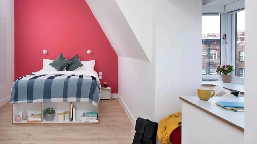 Bed with blue plaid blanket and storage bedroom at Scape Kings Cross in London Student Accommodation