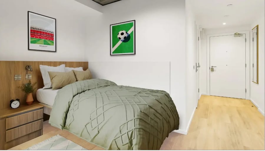 Bed bedside table alarm clock football posters bedroom at Wembley Arthur House in Wembley Student Accommodation