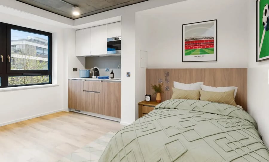 Bed with kitchen area and large window bedroom at Wembley Arthur House in Wembley Student Accommodation