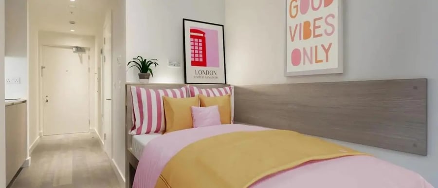 Bed with pink yellow bedding London poster bedroom at Chapter London Bridge in London Student Accommodation
