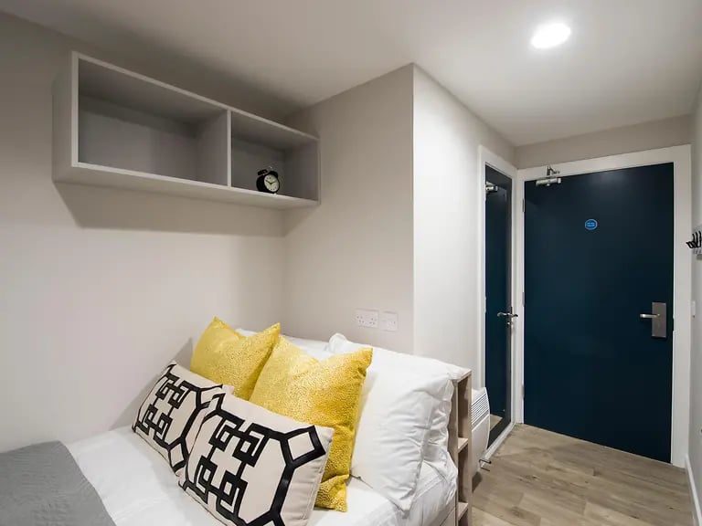 Bed pillows shelf and alarm clock bedroom at Riverside Quay in Stirling Student Accommodation