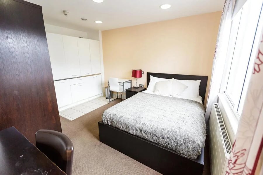 Bed desk cabinets white chairs bedroom at AXO Oxford Circus in London Student Accommodation