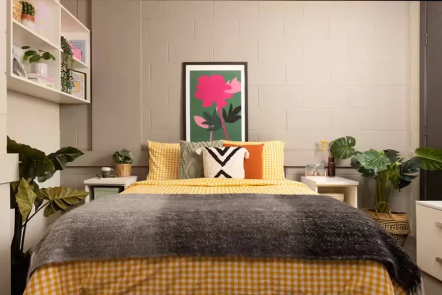Bed with yellow checkered bedding and gray throw bedroom at Spring Gardens in Aberdeen Student Accommodation
