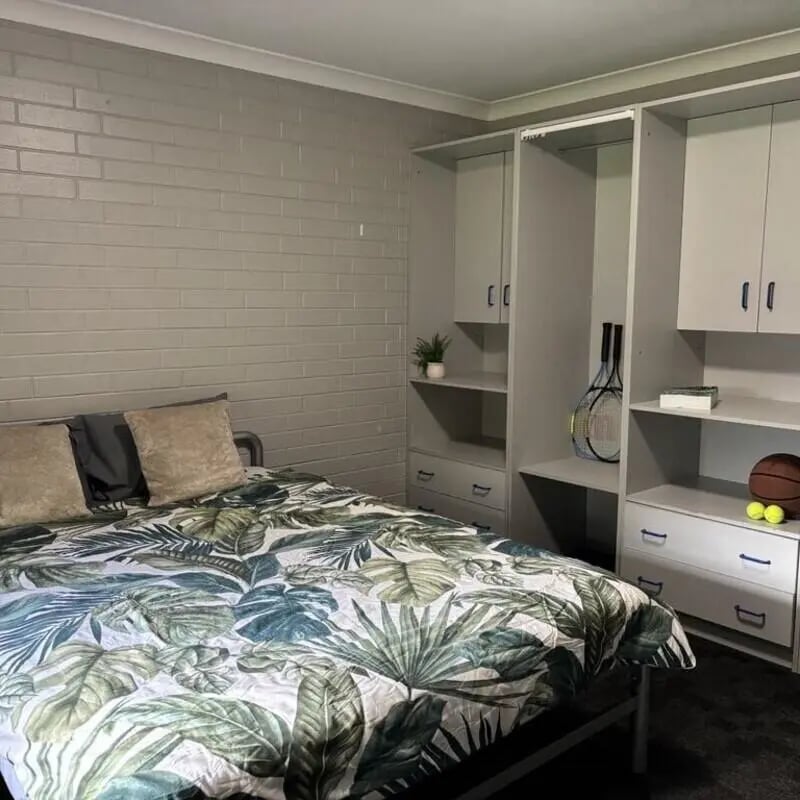 Bed with tropical duvet tennis racket basketball bedroom at Murdoch University Village in Perth Student Accommodation