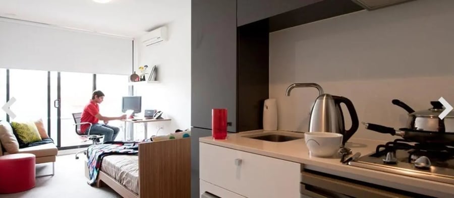 Desk bed sofa kettle stove kitchen living room at Student Living D2 in Melbourne Student Accommodation