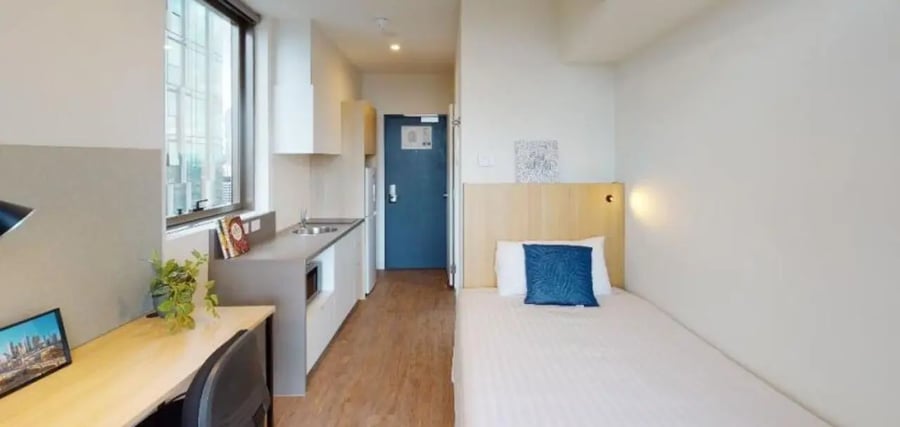 Desk kitchen and single bed student accommodation room at Unilodge Melbourne City in Melbourne Student Accommodation