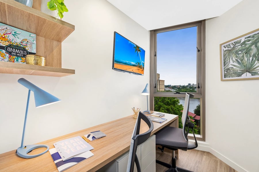 Desk lamp coloring book chairs TV window view study area at Scape St Lucia in Brisbane Student Accommodation