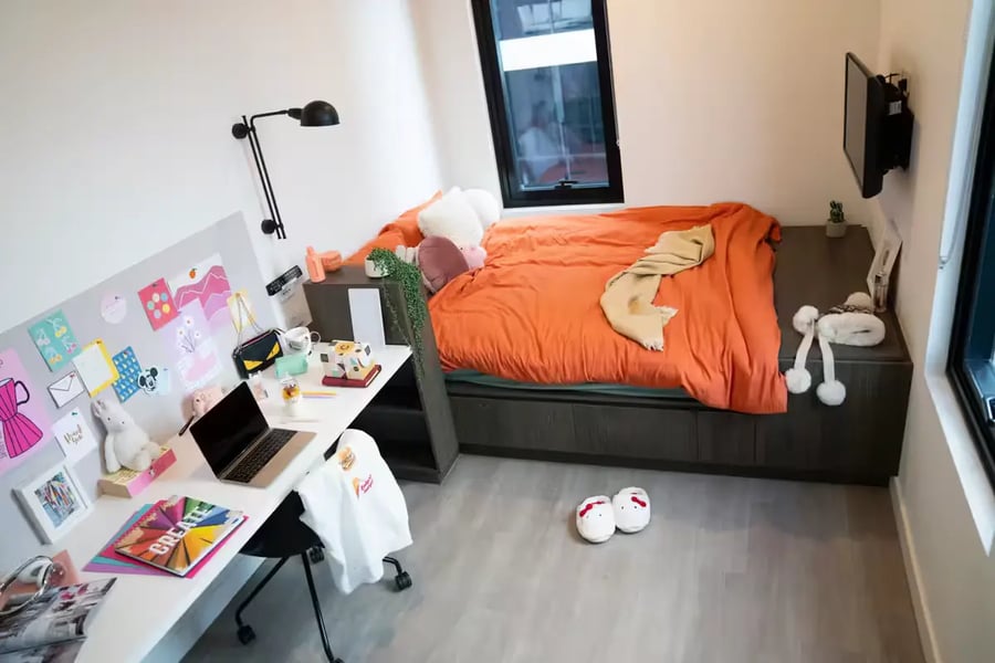 Bed desk lamp laptop and chair bedroom at Scape Cornell Place in Melbourne Student Accommodation