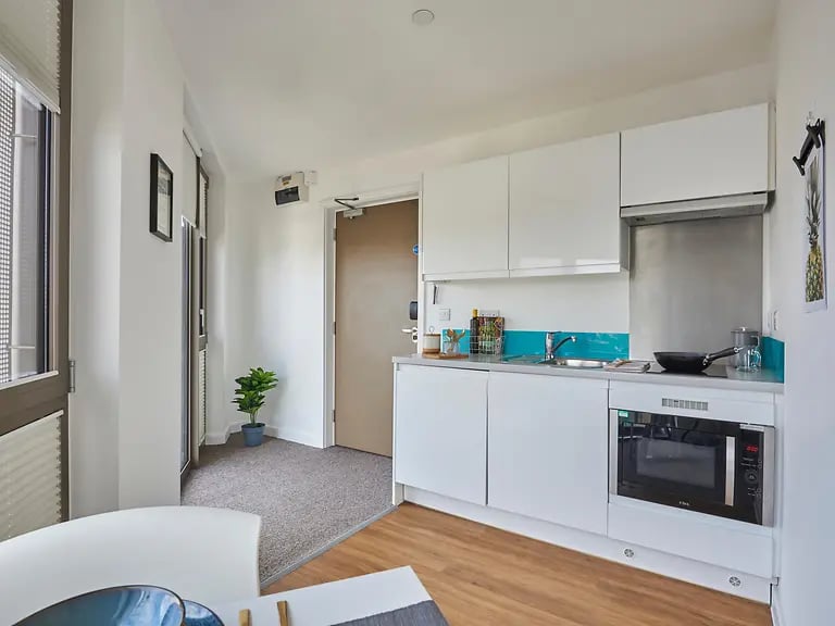 Modern white kitchen with microwave and sink kitchen at Felda House in Wembley Student Accommodation