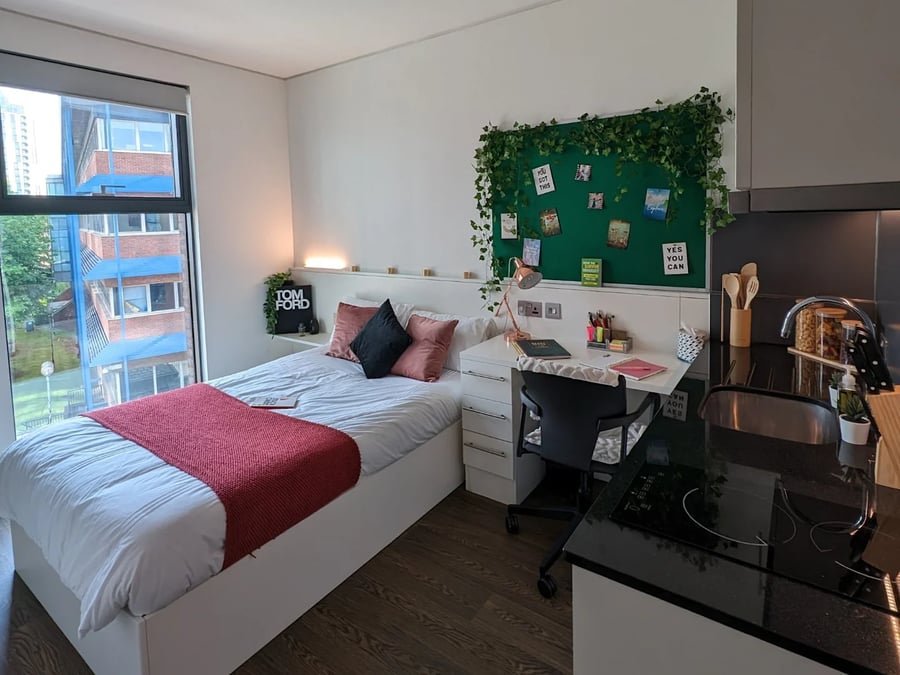Bed desk and kitchenette in studio apartment at Spring Mews in London Student Accommodation