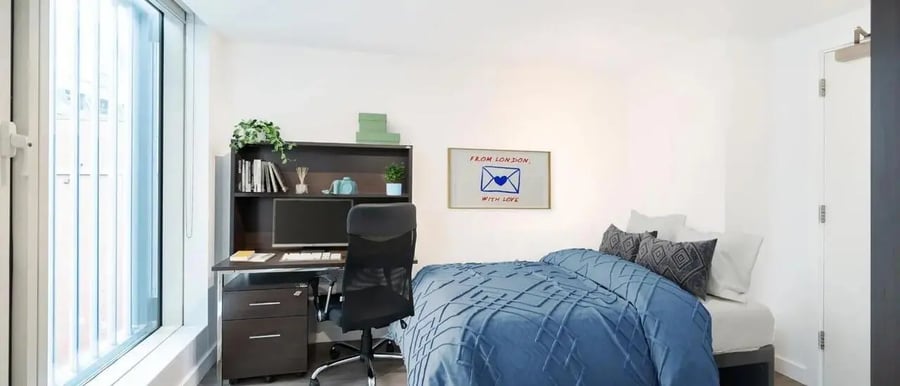 Bed desk chair bookshelf and framed art bedroom at Chapter Spitalfields in London Student Accommodation