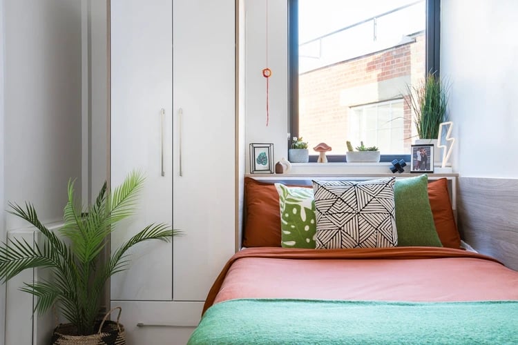 Closet bed pillows and plants bedroom at Arbour House in London Student Accommodation