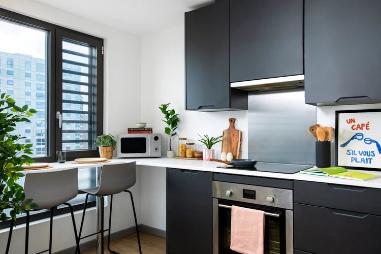 Modern dark cabinets microwave stools and counter kitchen at Hayloft Point in London Student Accommodation