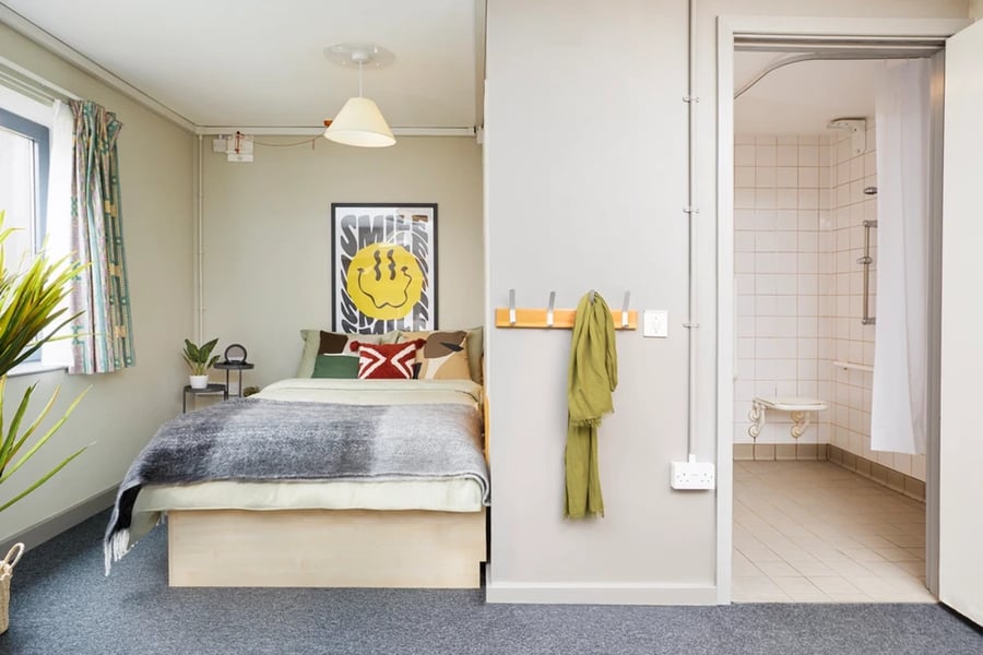 Bed with smiley poster and shower cubicle bedroom at Lakeside in Birmingham Student Accommodation