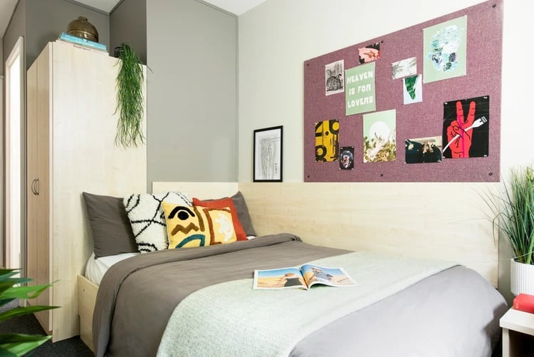 Bed with pillows wardrobe and artwork bedroom at Rahere Court in London Student Accommodation