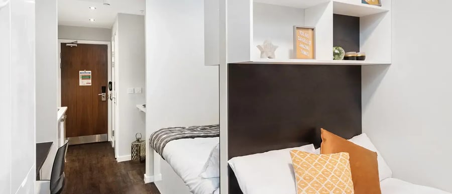 Bed with pillows and decor desk and door bedroom at Chapter Old Street in London Student Accommodation