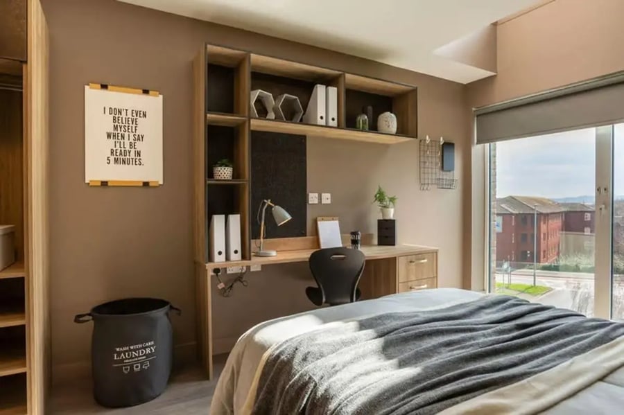 Desk shelving laundry basket bed bedroom at West Gate in Exeter Student Accommodation