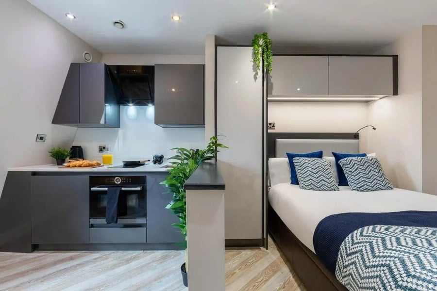 Modern studio kitchen and bed with pillows bedroom at dwell 121 Princess Street in Manchester Student Accommodation