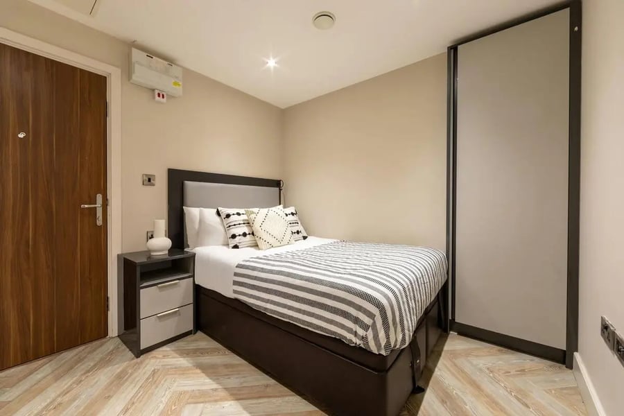 Bed bedside table large wardrobe bedroom at dwell 121 Princess Street in Manchester Student Accommodation