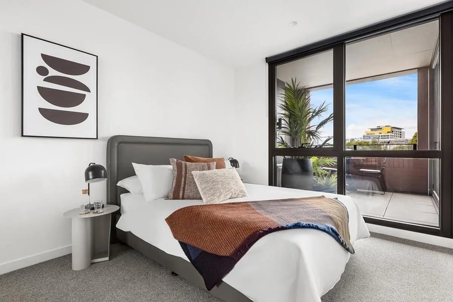 Bed with pillows throws and artwork Bedroom at Caulfield Place in Melbourne Student Accommodation