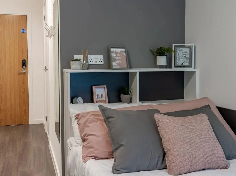 Bed with pillows shelf and door Bedroom at Pavilion Court London in London Student Accommodation