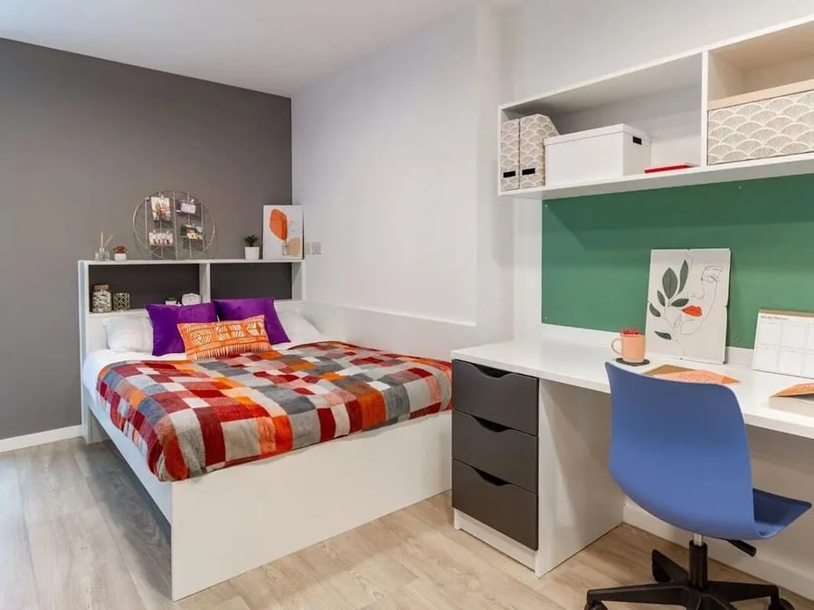 Bed desk and blue chair bedroom study area at Pavilion Court London in London Student Accommodation