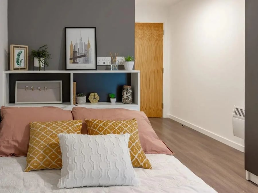 Bed with pink pillows and artwork Bedroom at Pavilion Court London in London Student Accommodation