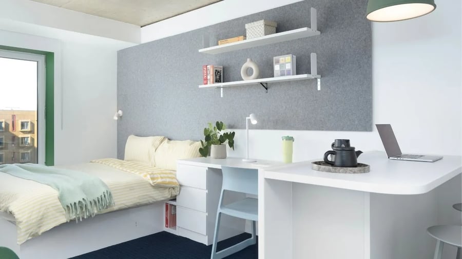 Bed desk lamp laptop and teapot bedroom study area at Scape Canada Water in London Student Accommodation