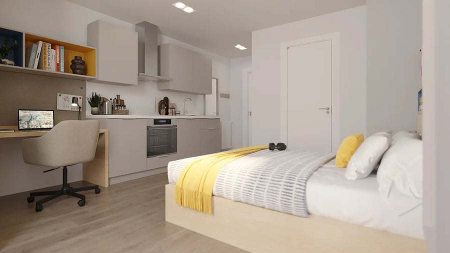 Desk chair laptop bed yellow blanket kitchen bedroom at Brigg Point in Bristol Student Accommodation