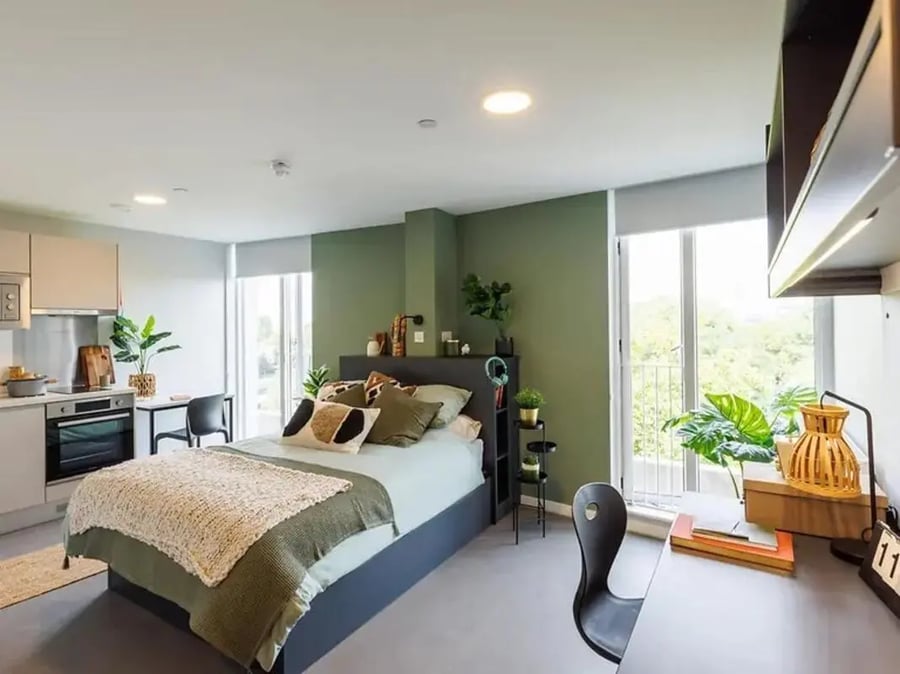 Bed kitchen desk plants student studio apartment at Element Bermondsey in London Student Accommodation
