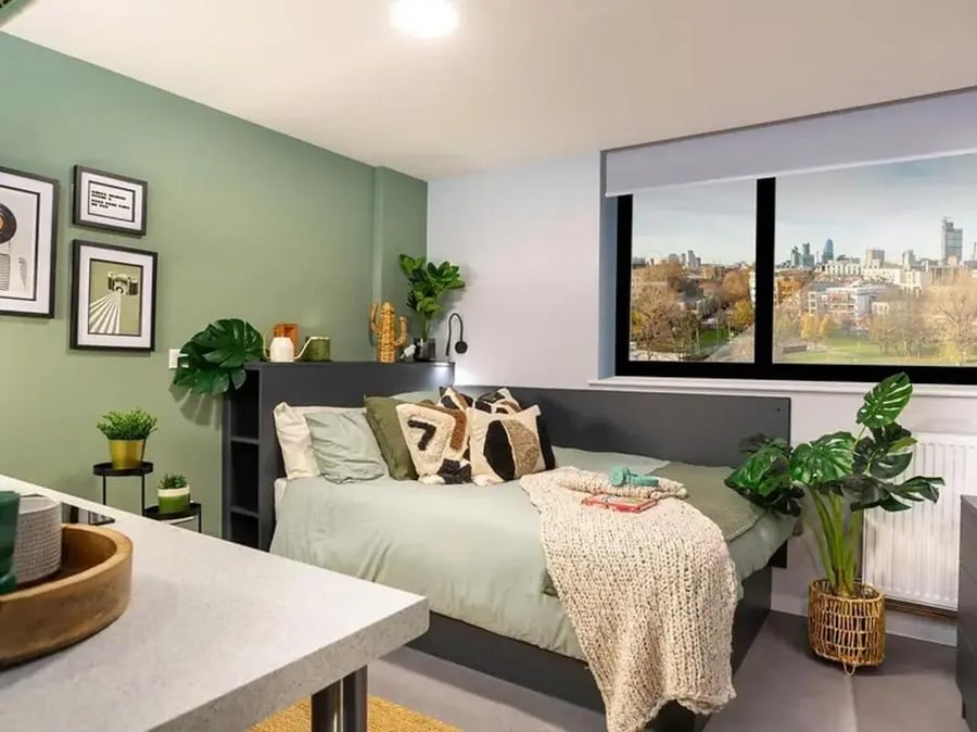 Bed with plants art and cityscape view bedroom at Element Bermondsey in London Student Accommodation