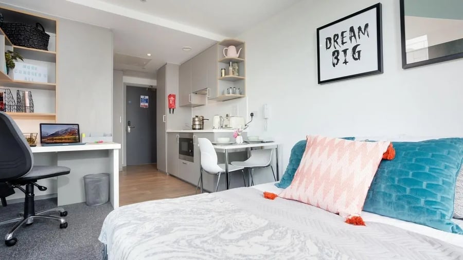 Desk laptop kitchen area bed pillows Studio apartment at Queen Street Studios in Exeter Student Accommodation