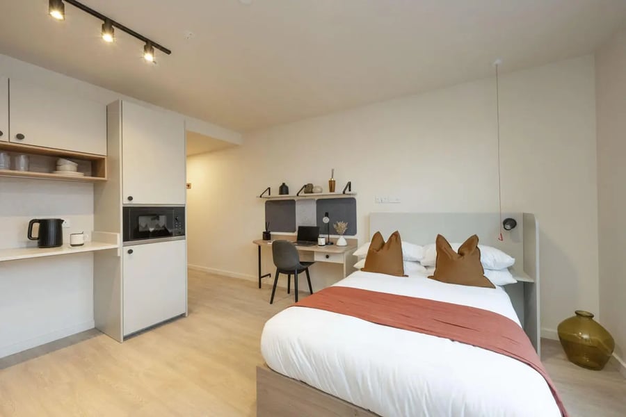 Kitchenette desk bed and pillows bedroom at Press House in London Student Accommodation