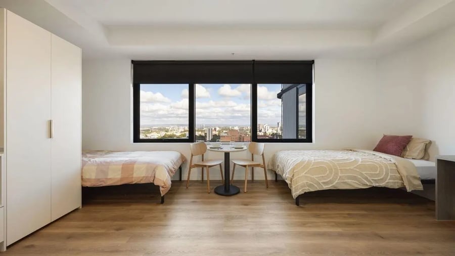 Two beds wardrobe table chairs bedroom exterior at UniLodge Perth Central in Perth Student Accommodation