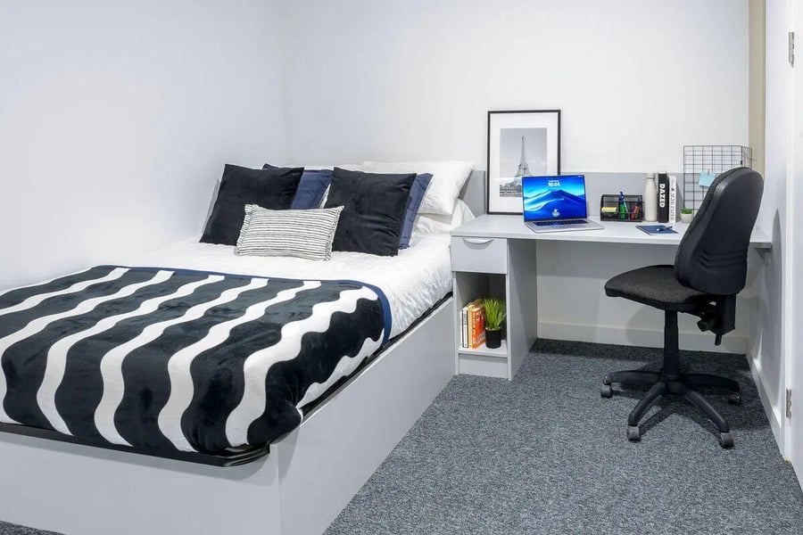 Bed with striped blanket and desk study area bedroom at True Leicester in Leicester Student Accommodation