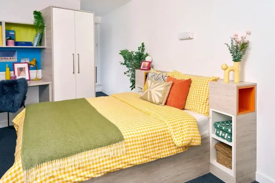 Bed with yellow checked duvet green throw wardrobe desk bedroom at Queen's Park House in Coventry Student Accommodation