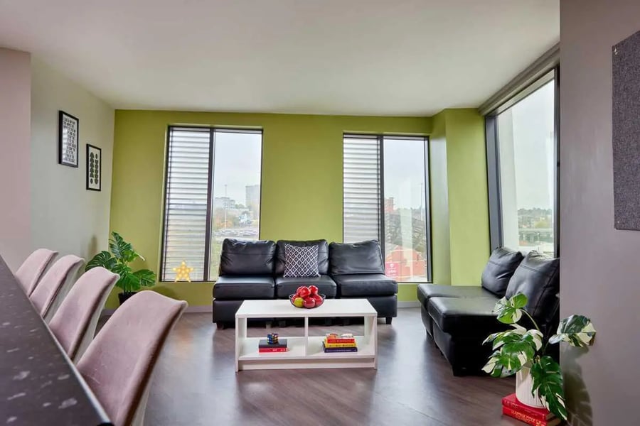 Black sofas white coffee table living room at Millennium View in Coventry Student Accommodation