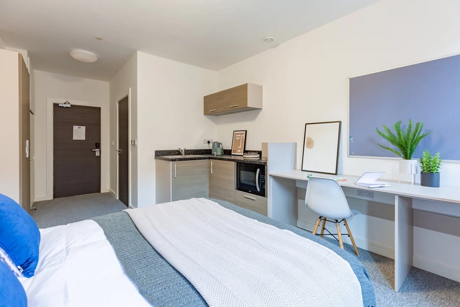 Bed desk kitchen area with microwave and plants Studio apartment at Radford Mill in Nottingham Student Accommodation