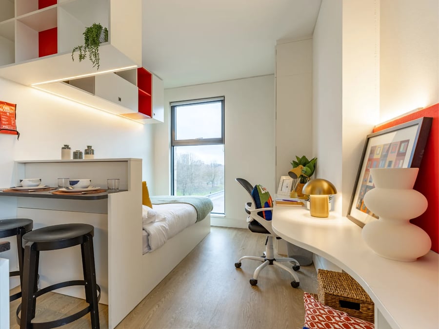 Bed desk chair shelves and stools student room at Spring Mews in London Student Accommodation