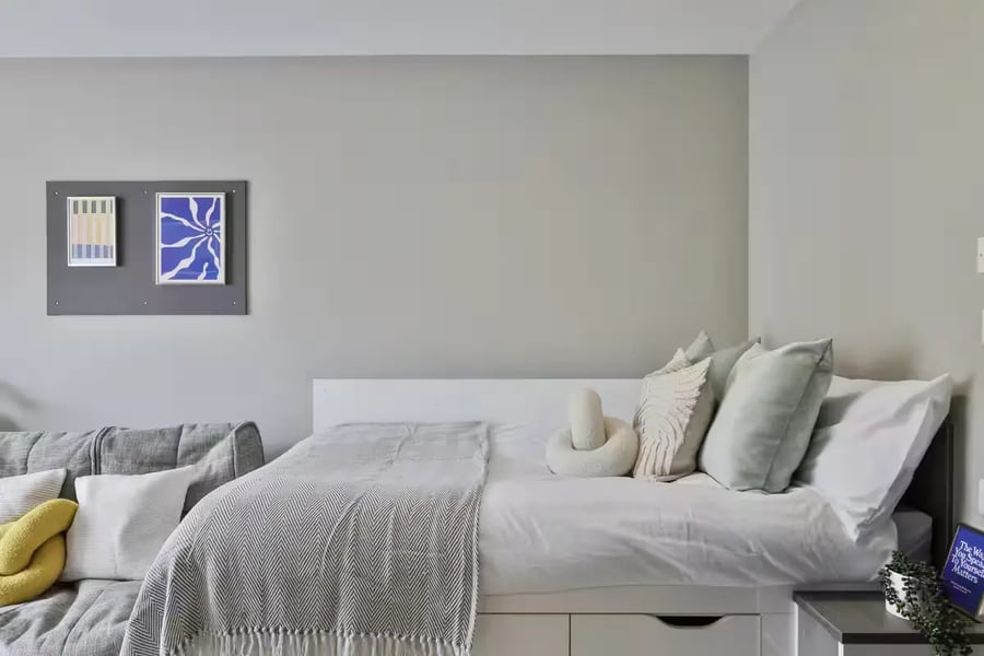 Bed with pillows and grey sofa Bedroom at Provincial House in Sheffield Student Accommodation