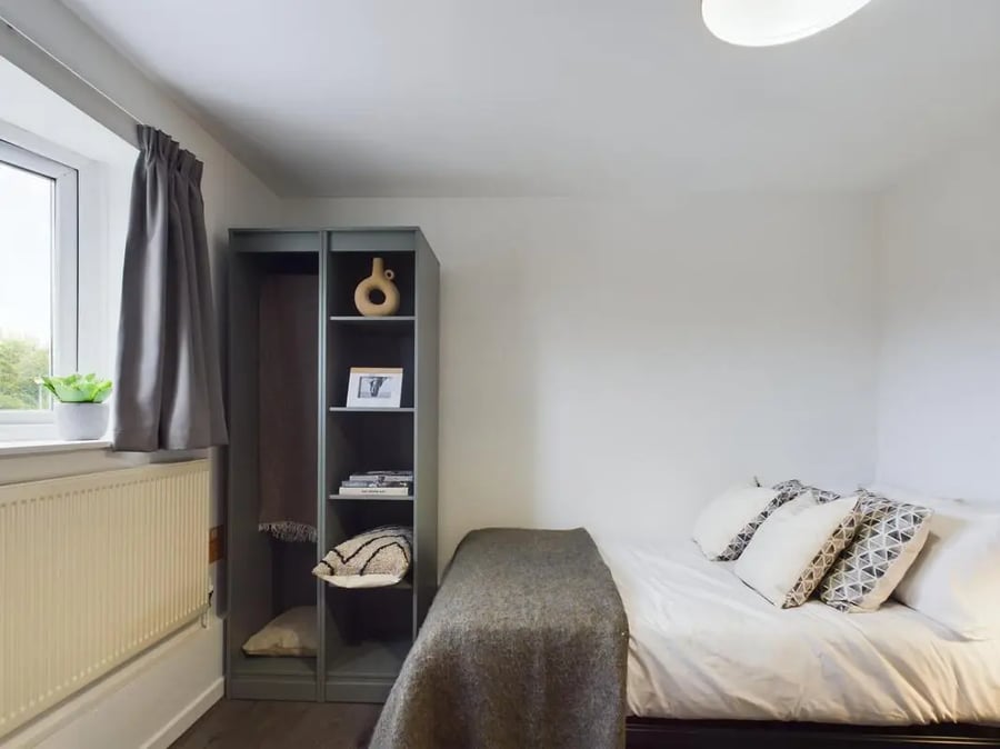 Bed with grey blanket and pillows shelving bedroom at 6 Bedroom House at 2, Flat 2, Windsor House, Clint Road West in Liverpool Student Accommodation