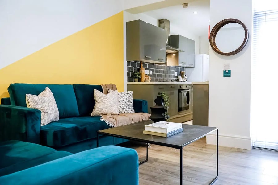 Teal sofa coffee table kitchen area living room at 6 Bedroom House at 3, Baggholme Road in Lincoln Student Accommodation