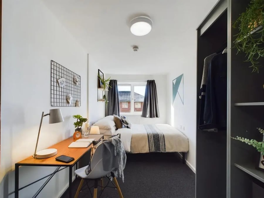 Bed desk chair plants wardrobe and bed. Bedroom at 3 Bedroom House at 6, Brookside in Derby Student Accommodation