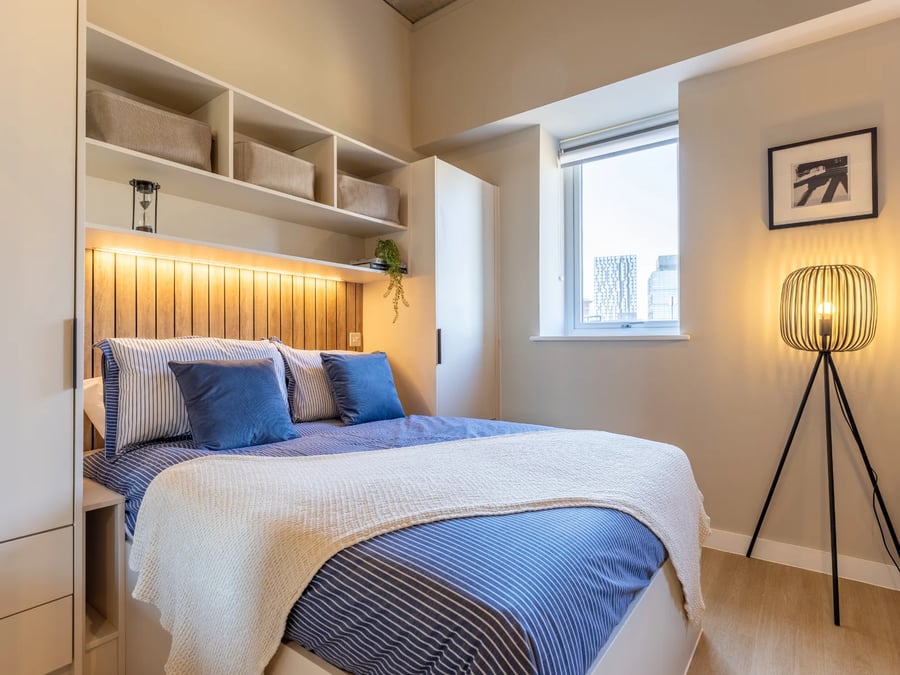 Bed with blue striped bedding bedside storage shelves Bedroom at Fitz and Knox in Cardiff Student Accommodation