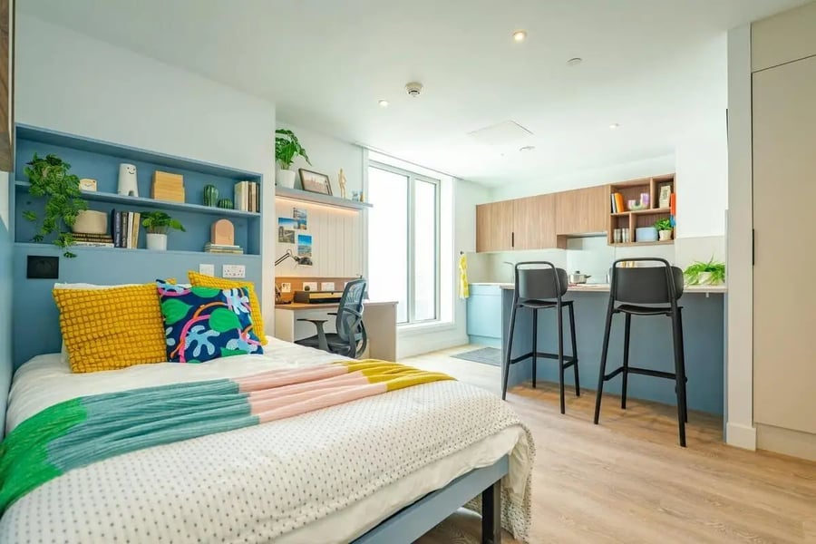 Bed desk and kitchen with bar stools studio apartment at The Propeller Quarter in Bristol Student Accommodation