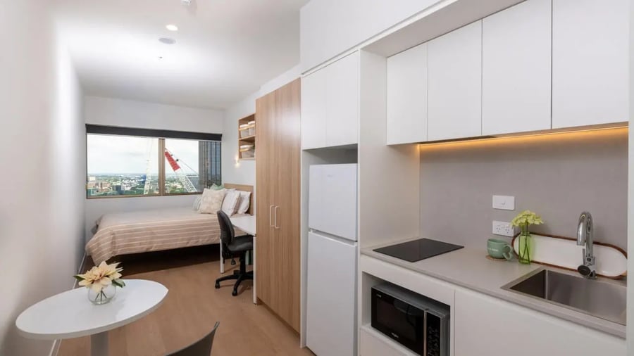 Bed desk kitchen area with microwave and fridge at UniLodge Brisbane City in Charleston Student Accommodation