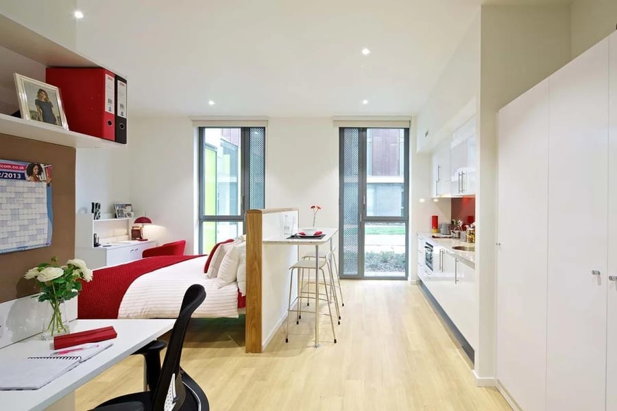 Bed desk bar kitchen and large white wardrobe studio at Wood Lane Studios in London Student Accommodation