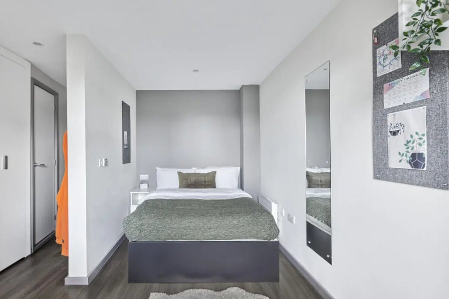 Bed with green blanket bedside table mirror bedroom at Gosford Gate in Coventry Student Accommodation