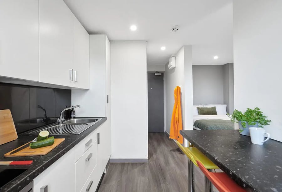 White kitchen with bed visible kitchen living room at Gosford Gate in Coventry Student Accommodation